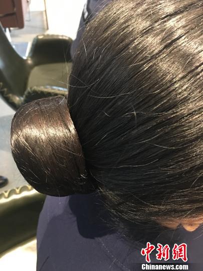 图为:统一盘发标准。 王潇婧 摄