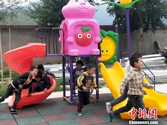 图为哇龙小学的孩子在捐赠的滑梯上玩耍。 李隽 摄