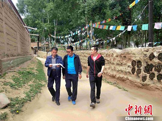 图为“第一书记”和驻村干部在村里走访。 李隽 摄