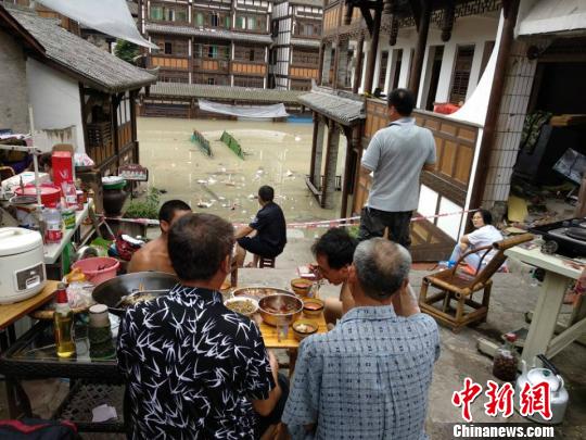 图为洪水涌进铜梁安居镇,市民在高处避险。 陈钢 摄