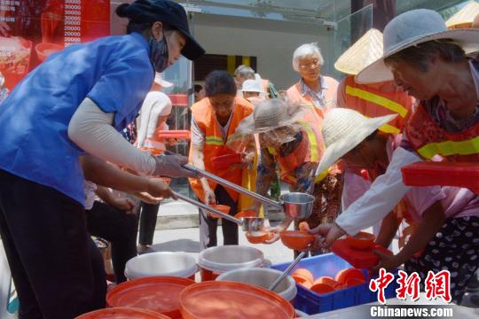 环卫工大爷大妈们排队领取午餐,汤和米管够吃饱。 朱志庚 摄