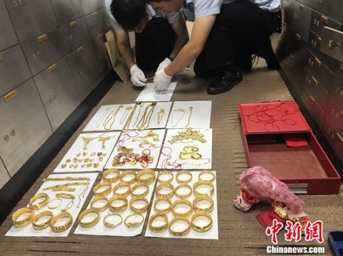 执行法官对箱内物品仔细清点,旁边书记员拿着笔刷刷埋头记录,制作金器首饰详细查封清单。供图