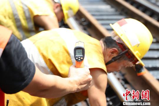 14日上午11时许,钢轨温度已接近60℃。图为温度计显示当时温度为60.9℃。 晏涛 摄