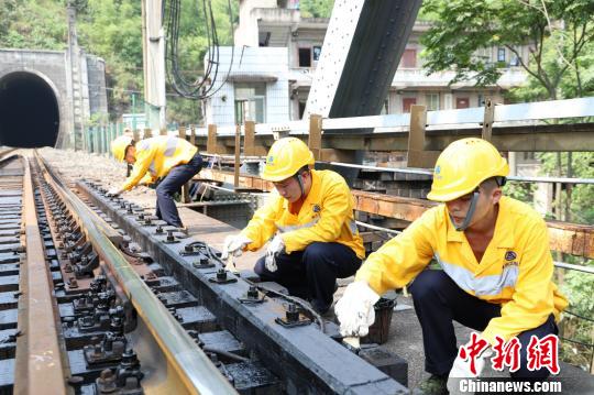 图为工作人员正在为位于位于重庆市北碚区的嘉陵江铁路钢大梁桥木枕涂沥青。 晏涛 摄