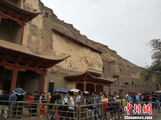 图为8月中旬,莫高窟九层楼前的游客如织。 冯志军 摄
