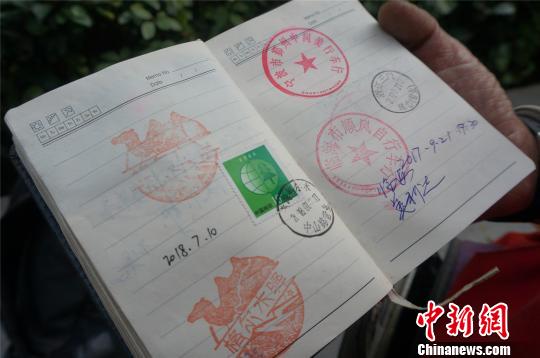 男子一年骑行万里宣传环保本子上盖满全国邮戳
