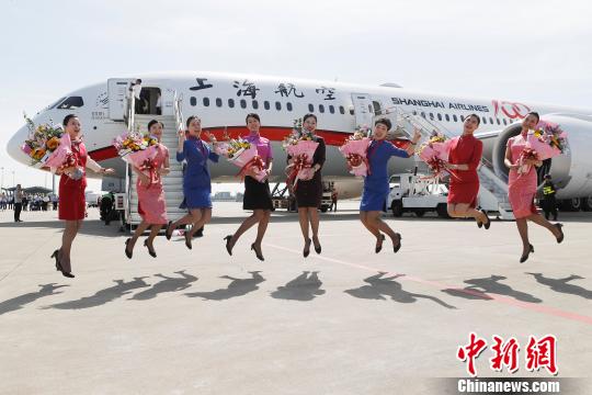 成功首航的乘务员们在停机坪上跳跃。 殷立勤 摄