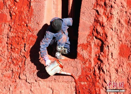 10月23日,布达拉宫管理处维修科工作人员开始对红宫进行粉刷。中新社记者 赵延 摄