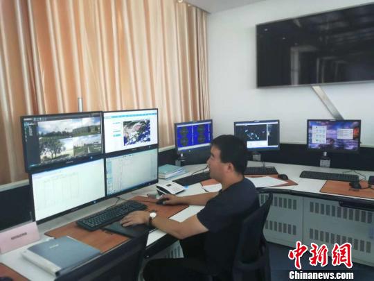 图为裴宗寿认真观测气象数据。 钟欣 摄