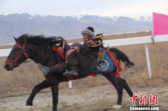 “马背上的民族”哈萨克族骑手以雪山为背景,给游客展示了各种马上绝技。 朱景朝 摄