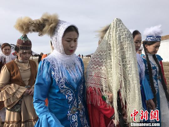 11月30日,生活在草原上的一对夫妻给游客演绎了哈萨克族婚礼,成都游客曾娟被邀请做伴娘, 朱景朝 摄