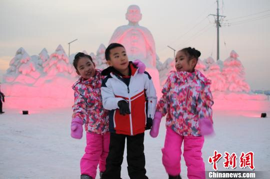 小朋友们在雪雕前快乐玩耍。 赵桂华 摄