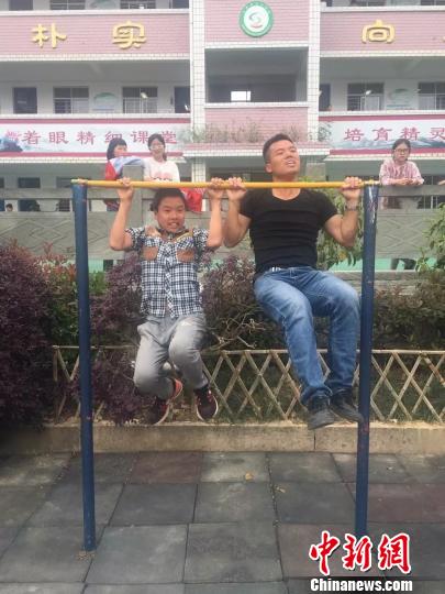 图为:仙居县上张乡中心学校郭永贵和学生在一起运动。台州市委宣传部提供