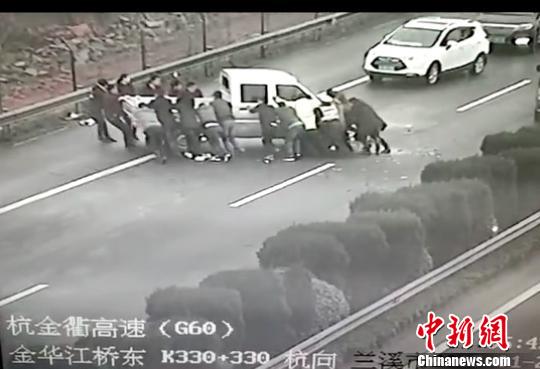 众人齐力抬车。金华高速交警提供