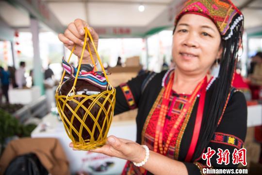 图为贫困户展示特色农产品 王子谦 摄