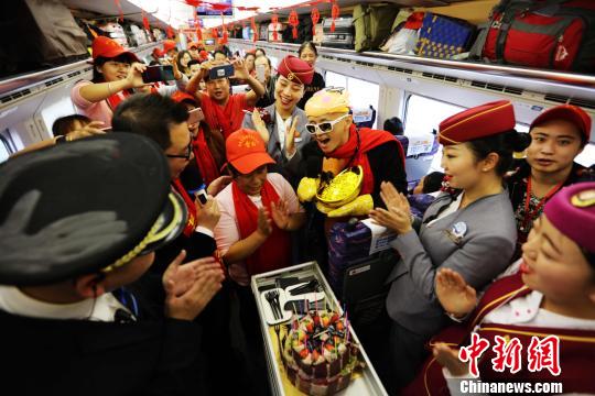 图为志愿者与乘务员为外出务工人员过生日。中国铁路昆明局集团供图