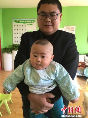 抱着孩子的杜洪峰 朱玉芳 摄