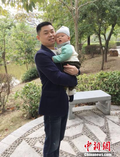 抱着孩子的鲁启新 朱玉芳 摄