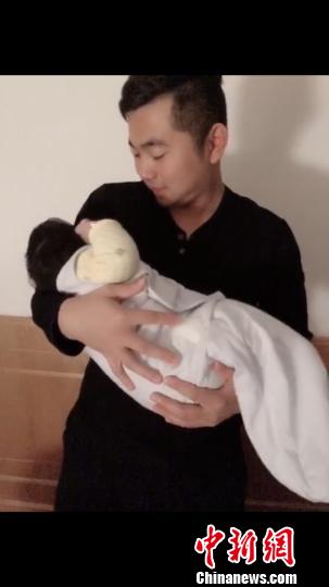 抱着孩子的刘宝 朱玉芳 摄