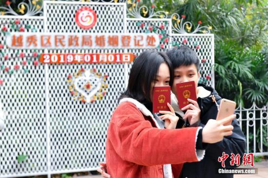 1月1日,一对新人领取结婚证后在日期板前合影留念。2019年1月1日是新年首天,“一生一世一双人”的寓意吸引不少新人在当天办理结婚登记。据广州市民政局统计,截至当天12时,广州办理结婚登记451对。中新社记者 陈骥旻 摄