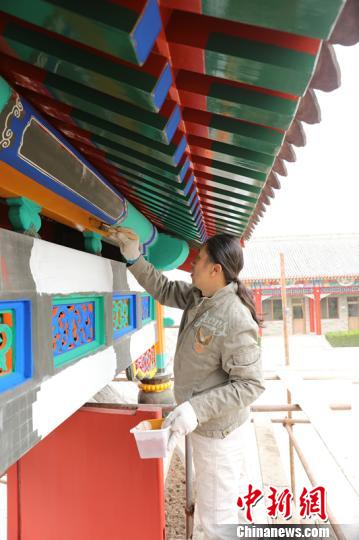 吴书瑞正在给古建筑的垂花门刷大色。首都文明办供图