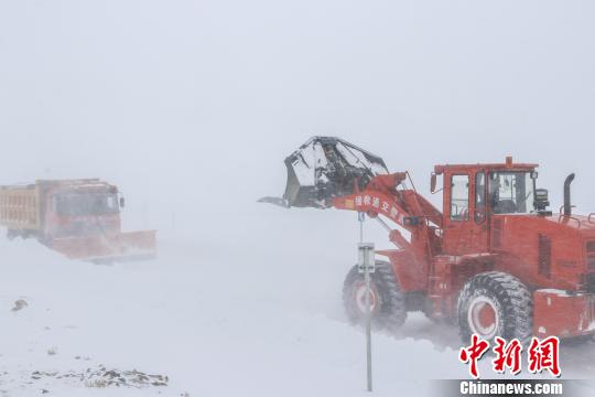 图为武警某部交通三支队官兵冒雪清理路面积雪。 罗斐 摄
