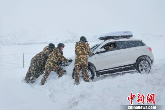 图为武警某部交通三支队官兵冒雪救援滞留车辆。 席培顺 摄