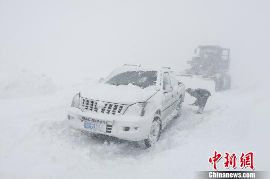 图为武警某部交通三支队官兵冒雪救援滞留车辆。 罗斐 摄