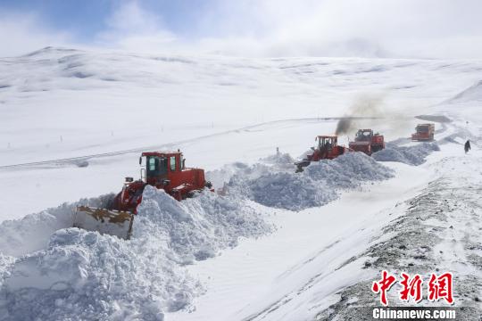 图为武警某部交通三支队多机协同作业清理路面积雪。 王邦跃 摄