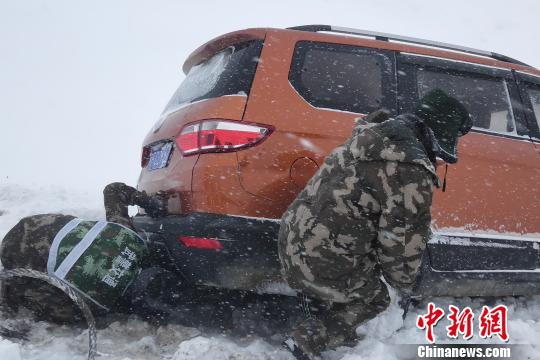图为武警某部交通三支队官兵冒雪救援滞留车辆。 吴茂振 摄