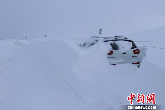 图为被暴雪掩盖的过往车辆。 王邦跃 摄