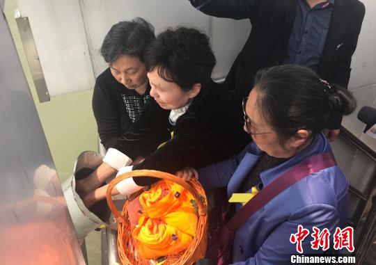 青碧涛、青晋进、青欣欣一同将父母的骨灰撒向大海。 郑江洛 摄