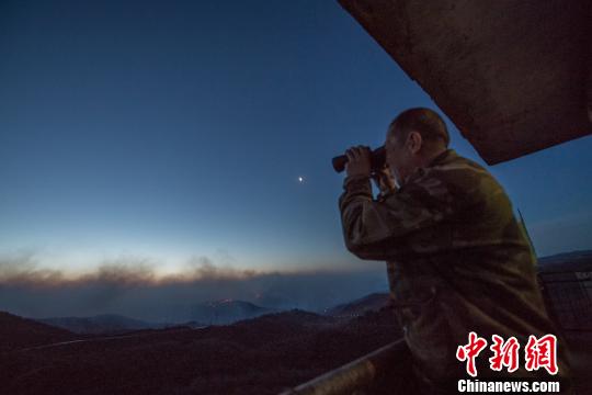 图为郭学强正在瞭望火情。 武俊杰 摄