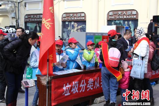 小志愿者普及垃圾分类知识。 邹德日 摄