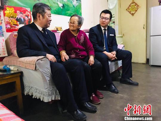 陶剑勇(左)与同事一起看望旷秀霞。 艾庆龙 摄