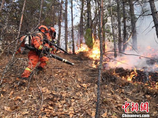 图为消防指战员扑救一线明火 图为队员向火场一线开进 摄