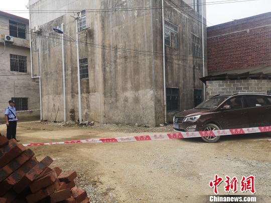图为柳州市黄岭村汶村的案发现场,院子停放有一辆汽车,房子周围拉起的警戒线,有多名警察在现场把守,警方在现场设置了数字标记。 朱柳融 摄