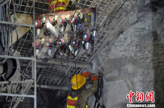 图为一位建设者在有毒有害气体监测仪下施工。 缪超 摄