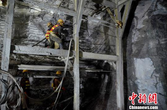 图为建设者佩戴防毒面具进行隧道掘进。 缪超 摄
