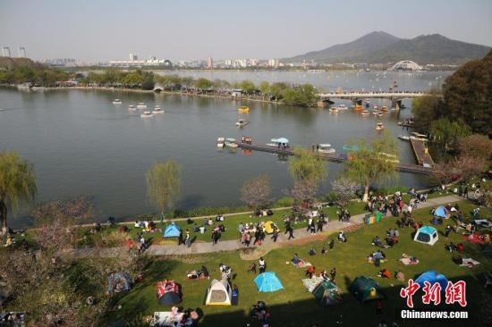 3月31日,市民和游客在南京玄武湖公园内游玩。当日,南京天气晴好,人们纷纷赏花游园,享受春光。中新社记者 泱波 摄
