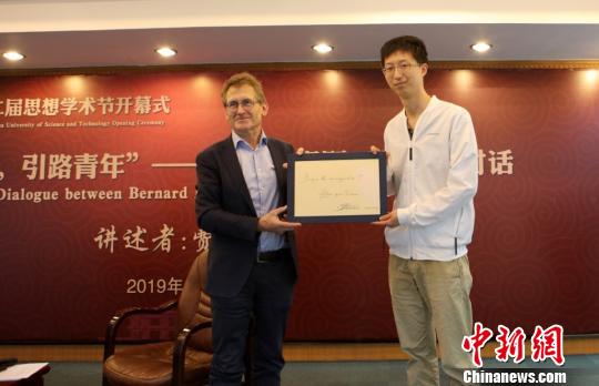 费林加教授(左)为中国大学生年度人物、华理优秀博士生张琦题字。供图