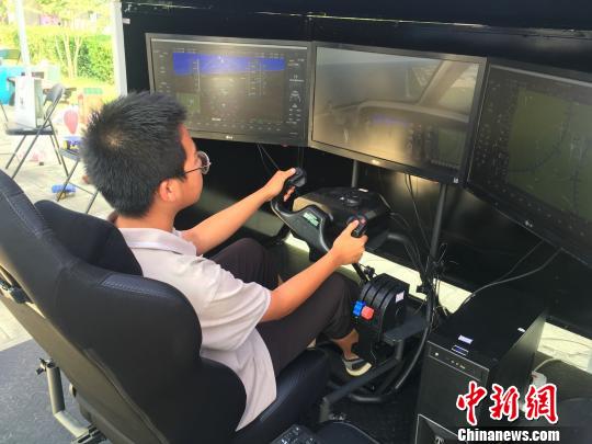 学生们体验高科技项目。图为一名学生驾驶飞行模拟机,进行飞行实践操纵体验。 杜燕 摄