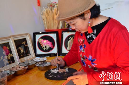 图为河湟民间刺绣传承人俞兰正在制作河湟石画。 鲁丹阳 摄