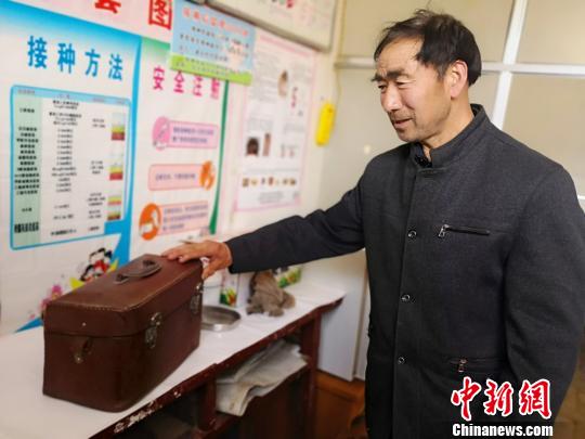 焦宽俊为记者介绍当年行医背过的药箱。 高展 摄