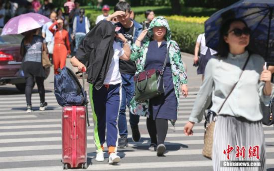 资料图:民众在高温晴晒天气中出行。中新社记者 贾天勇 摄