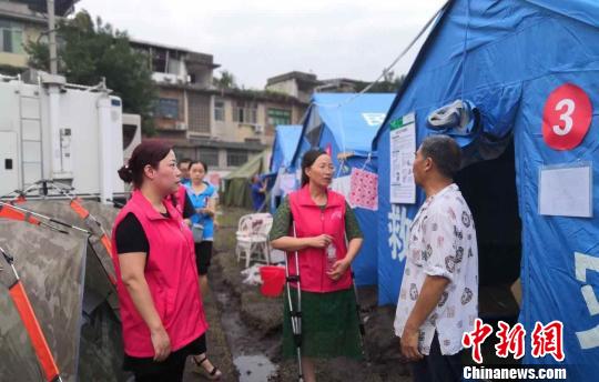 长宁震区杵着双拐的志愿者:希望爱的火炬永传递