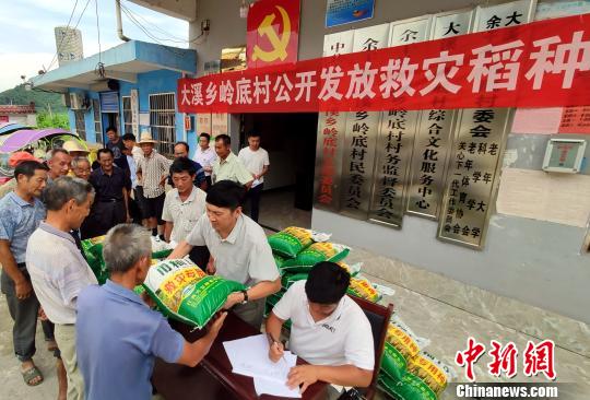 7月17日下午,江西余干县大溪乡岭底村,村小组长在领取救灾稻种。 王昊阳 摄