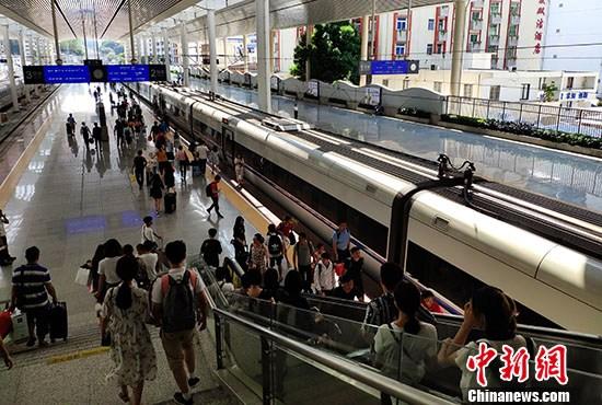 资料图:旅客在火车站站台准备乘车。 中新社记者 吕明 摄