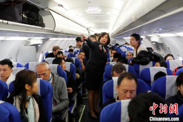 吉晓春在客舱与旅客交流。 殷立勤 摄