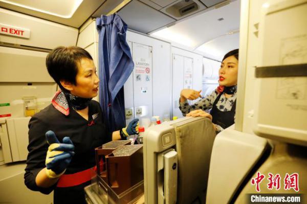 马文菁在客舱厨房为旅客准备餐食。 殷立勤 摄